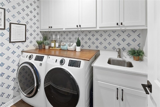 laundry area featuring cabinets, washing machine and clothes dryer, and sink