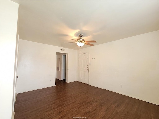 empty room featuring dark wood-type flooring and ceiling fan