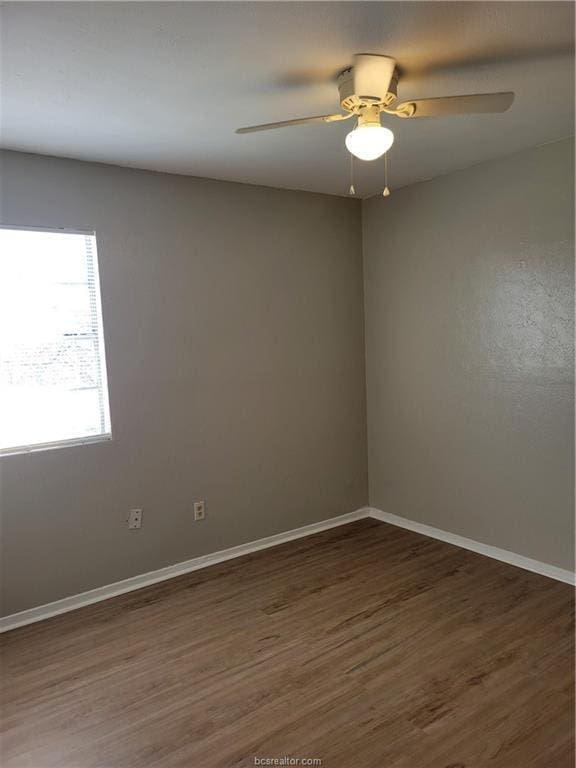 empty room featuring ceiling fan and dark hardwood / wood-style floors