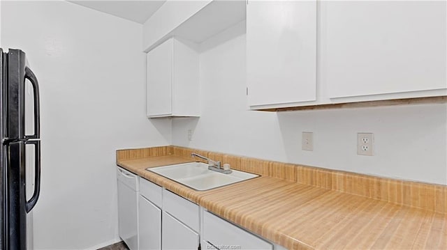 kitchen featuring black refrigerator, white cabinetry, dishwasher, and sink