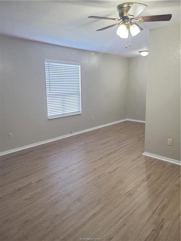 empty room with hardwood / wood-style floors and ceiling fan