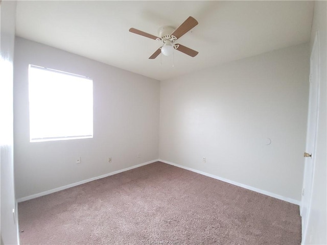 carpeted spare room with ceiling fan