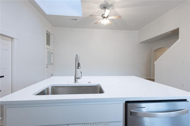 kitchen with dishwasher, a kitchen island with sink, sink, light stone countertops, and white cabinetry