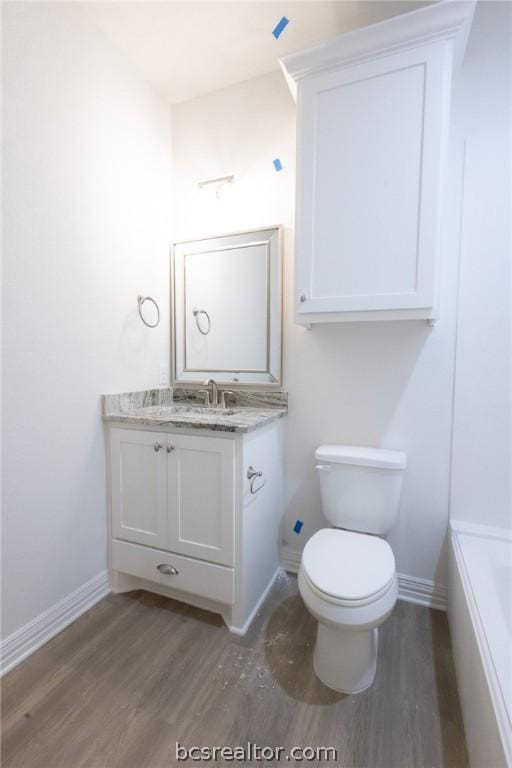 bathroom with wood-type flooring, vanity, and toilet