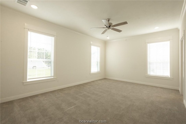 carpeted empty room featuring a wealth of natural light, ceiling fan, and ornamental molding