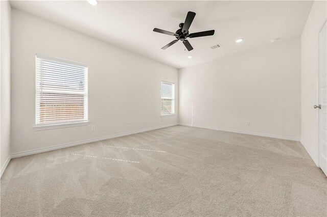 spare room featuring light colored carpet and ceiling fan