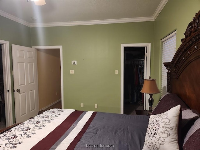 bedroom featuring a spacious closet, a closet, and ornamental molding