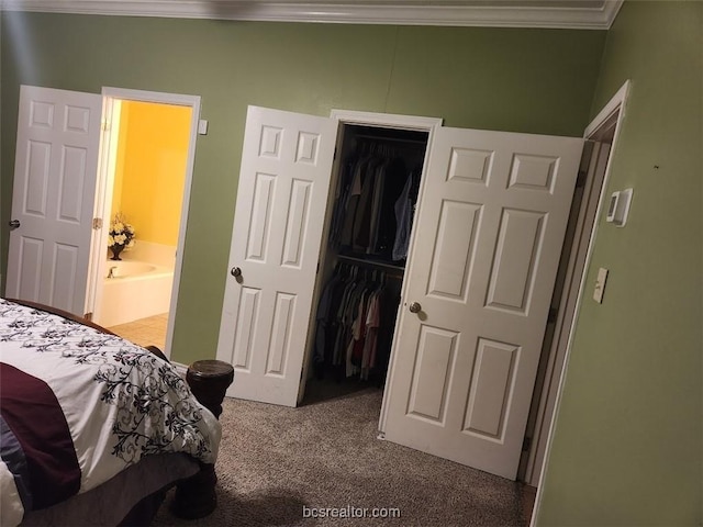 bedroom with carpet flooring, ensuite bath, a spacious closet, crown molding, and a closet