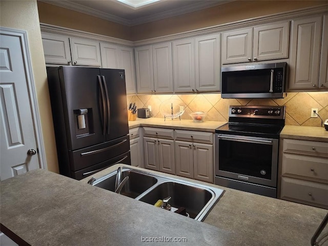 kitchen featuring decorative backsplash, crown molding, sink, and stainless steel appliances