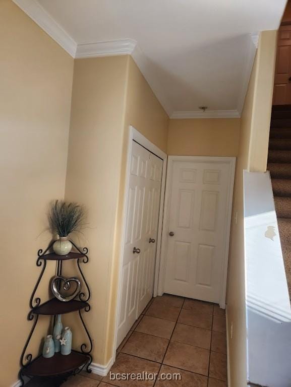 hallway with light tile patterned floors and ornamental molding