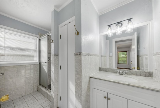 bathroom featuring vanity, crown molding, and tile walls