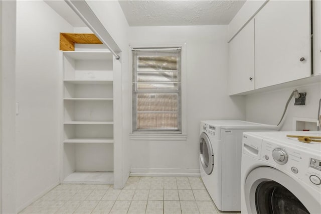 laundry room with cabinets, independent washer and dryer, and a textured ceiling