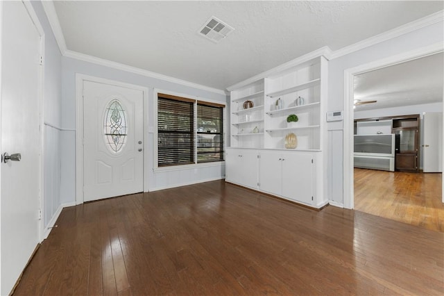 entrance foyer with a textured ceiling, ceiling fan, wood-type flooring, and crown molding