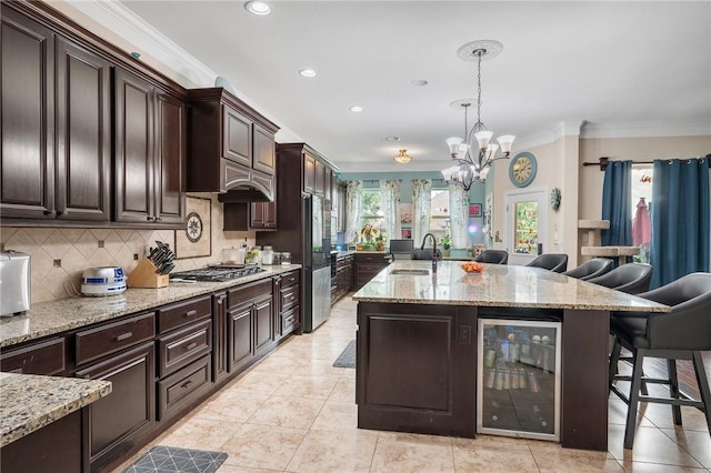 4314 Hadleigh Ln, College Station, TX 77845 - kitchen featuring beverage cooler, a sink, ornamental molding, a breakfast bar, and gas cooktop
