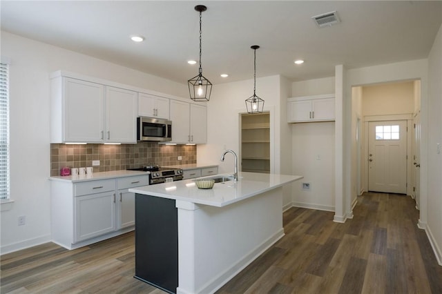 2784 Messenger Way, Bryan, TX 77803 - kitchen with appliances with stainless steel finishes, a sink, decorative backsplash, white cabinetry, and dark wood finished floors