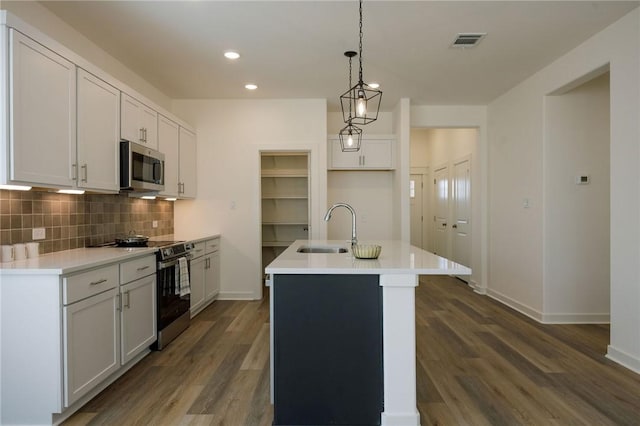2784 Messenger Way, Bryan, TX 77803 - kitchen with a sink, appliances with stainless steel finishes, decorative backsplash, dark wood finished floors, and a center island with sink