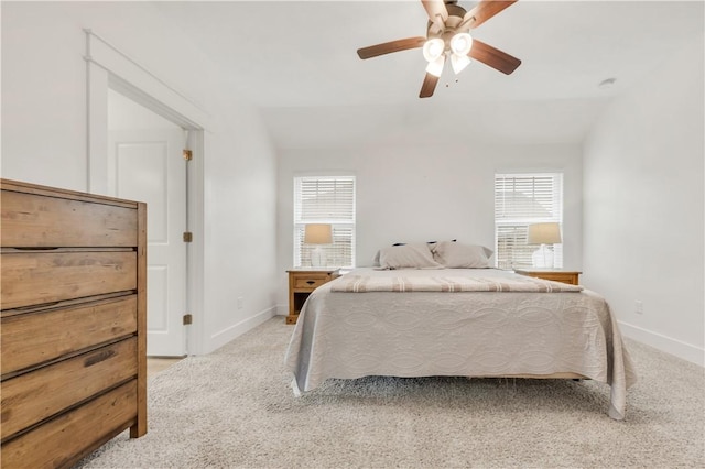 bedroom with baseboards, multiple windows, and light colored carpet