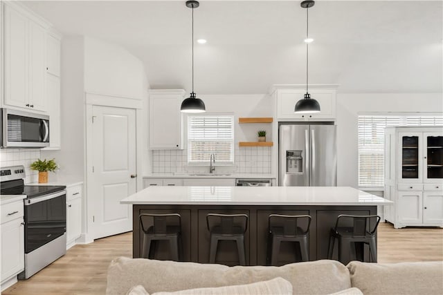 kitchen featuring a sink, appliances with stainless steel finishes, light wood-style floors, and light countertops