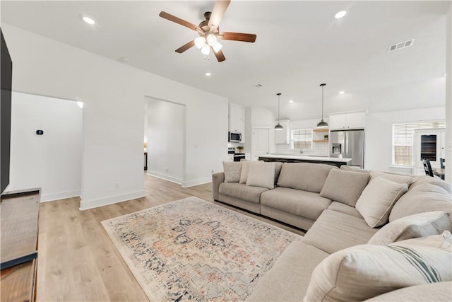 living area featuring visible vents, light wood-style floors, baseboards, recessed lighting, and a ceiling fan