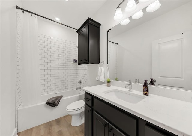 full bath with toilet, wood finished floors, shower / bath combo, and vanity
