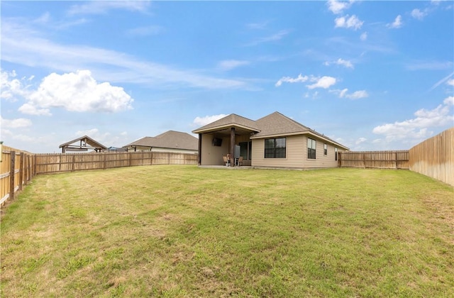 back of property with a lawn and a fenced backyard
