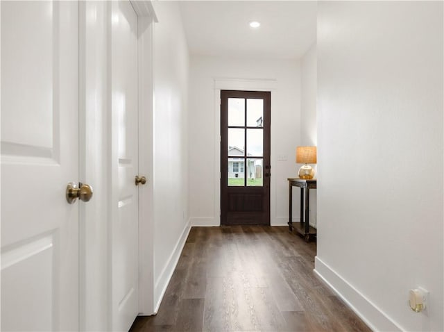 doorway to outside with baseboards and dark wood-type flooring