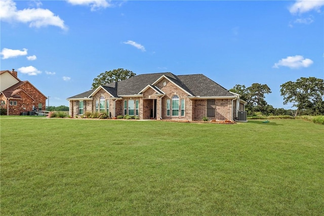 10008 Henley Cv, Iola, TX 77861 - view of front facade featuring a front yard, brick siding, and central air condition unit