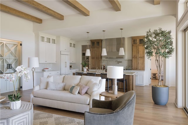 living room with beamed ceiling and light wood-type flooring