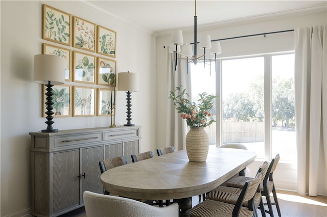 dining space with a chandelier, light hardwood / wood-style floors, and crown molding