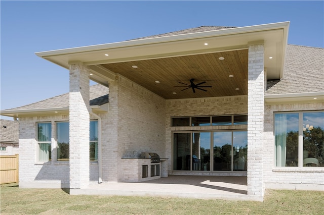 rear view of house with ceiling fan, exterior kitchen, and a patio