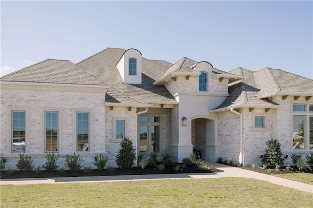 french country style house featuring a front yard