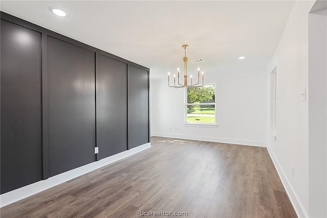 unfurnished dining area featuring hardwood / wood-style flooring and a notable chandelier