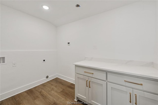 laundry area featuring electric dryer hookup, dark hardwood / wood-style flooring, cabinets, and washer hookup