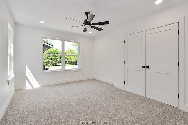 unfurnished bedroom featuring ceiling fan, a closet, and light colored carpet