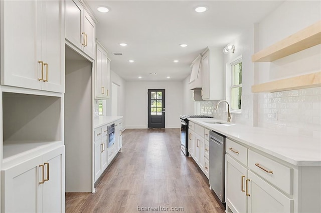 kitchen featuring white cabinetry, sink, dark wood-type flooring, stainless steel appliances, and backsplash