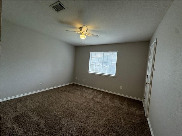 empty room featuring ceiling fan and dark colored carpet