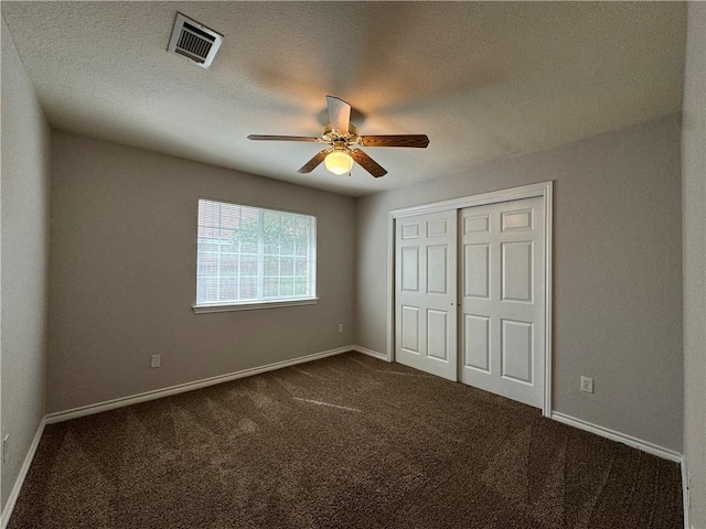 unfurnished bedroom featuring a closet, ceiling fan, and dark colored carpet