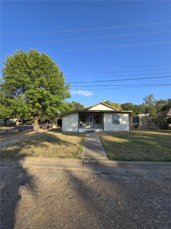 view of front of home featuring covered porch and a front lawn