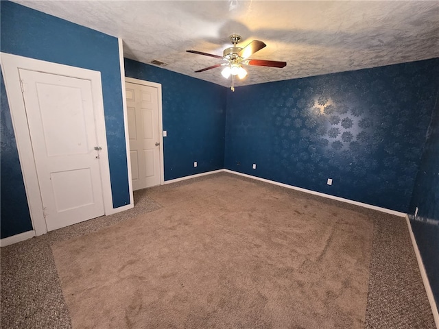 unfurnished bedroom featuring carpet flooring, ceiling fan, and a textured ceiling