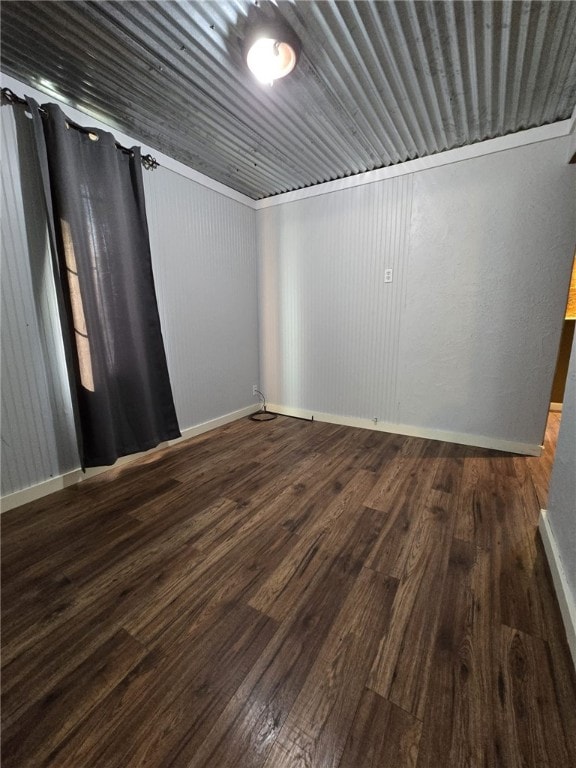 unfurnished room with dark wood-type flooring and ornamental molding