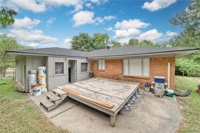 back of house featuring a lawn and a deck