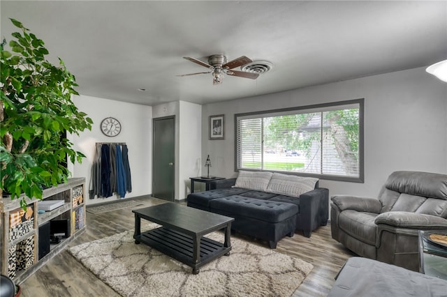 living room featuring wood-type flooring and ceiling fan