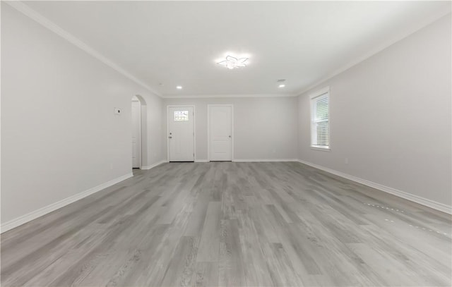 301 S Hutchins St, Bryan, TX 77803 - unfurnished living room with arched walkways, baseboards, crown molding, light wood-type flooring, and recessed lighting