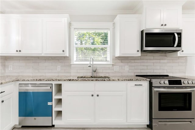 301 S Hutchins St, Bryan, TX 77803 - kitchen featuring appliances with stainless steel finishes, a sink, white cabinets, crown molding, and light stone countertops