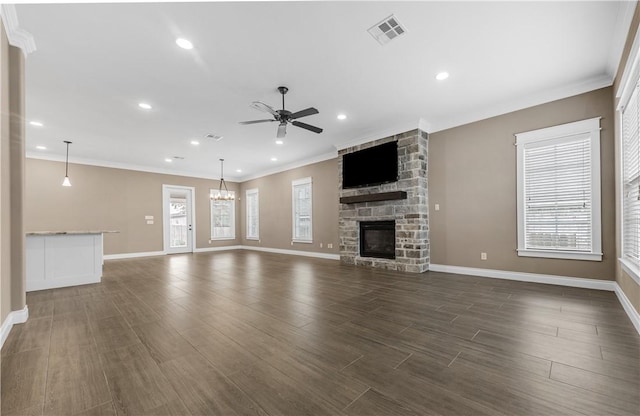 unfurnished living room featuring dark hardwood / wood-style floors, crown molding, a fireplace, and ceiling fan with notable chandelier