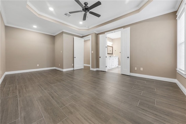 unfurnished room with dark hardwood / wood-style floors, ceiling fan, crown molding, and a tray ceiling