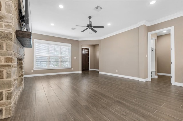 unfurnished living room featuring dark hardwood / wood-style floors, ceiling fan, a stone fireplace, and crown molding