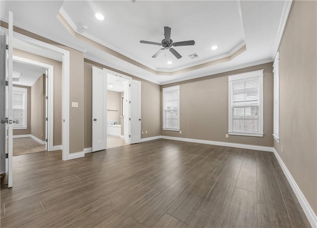 unfurnished room featuring a tray ceiling, ceiling fan, dark hardwood / wood-style flooring, and crown molding