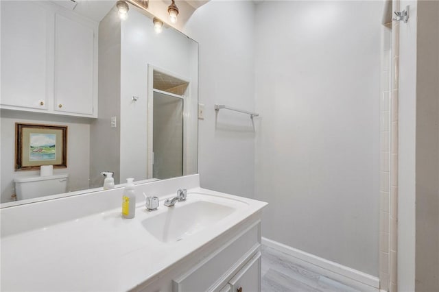 bathroom with vanity, toilet, wood-type flooring, and walk in shower