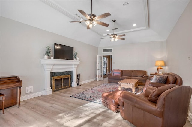 living room with ceiling fan, a fireplace, light hardwood / wood-style floors, and vaulted ceiling